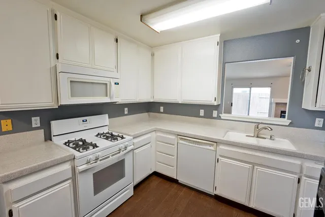 a kitchen with white cabinets and white appliances