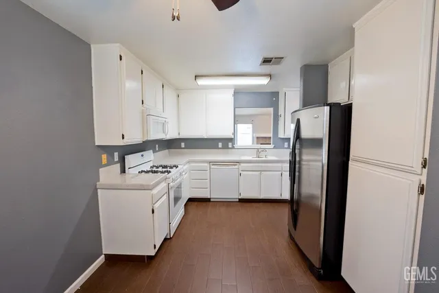 a kitchen with white cabinets and stainless steel appliances