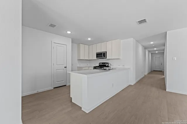 a kitchen with granite countertop a stove sink and cabinets
