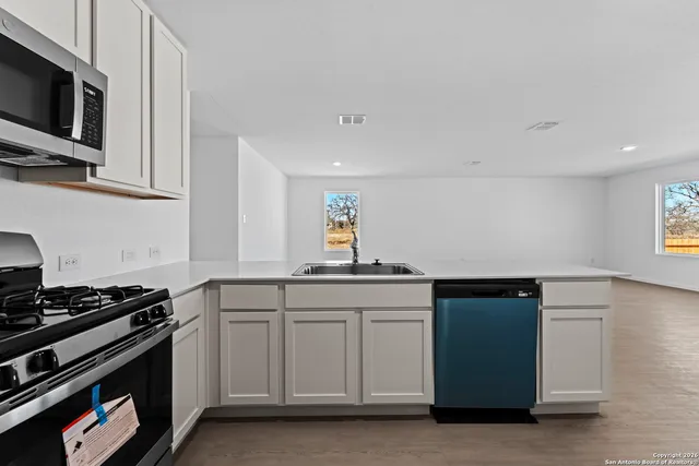 a view of a kitchen with a sink and a refrigerator