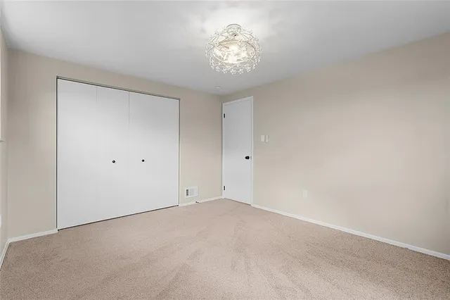 an empty room with ceiling fan and window