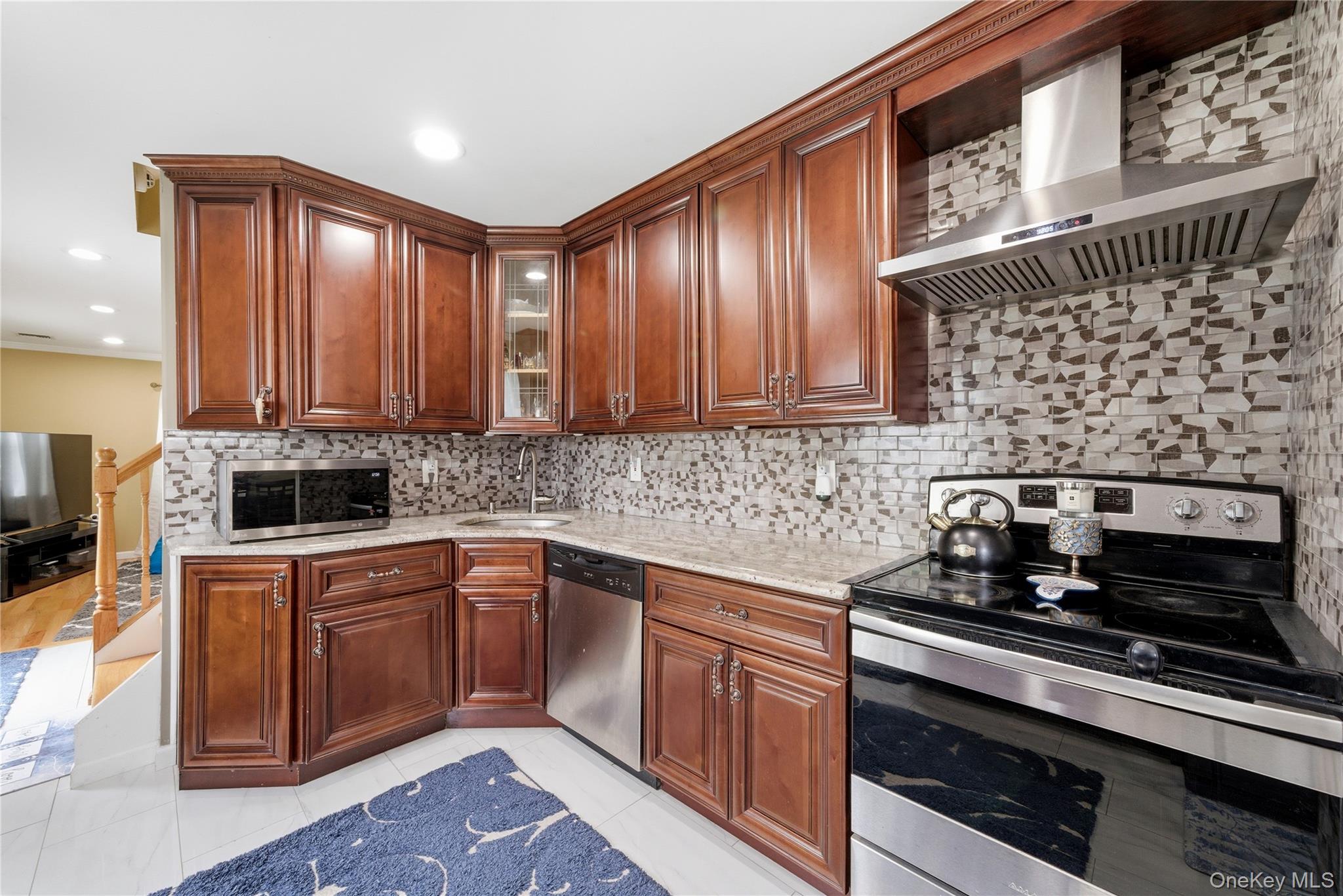 50 Ridge Lane Levittown, NY 11756 - Photo 7 of 27 a kitchen with stainless steel appliances granite countertop wooden cabinets a stove top oven a sink and dishwasher