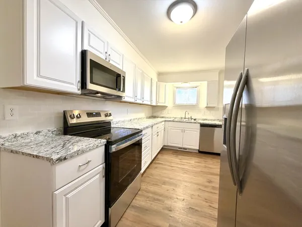 a kitchen with stainless steel appliances granite countertop a stove a sink dishwasher a refrigerator and a microwave