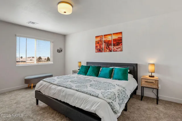 a bedroom with a bed and a lamp next to a window