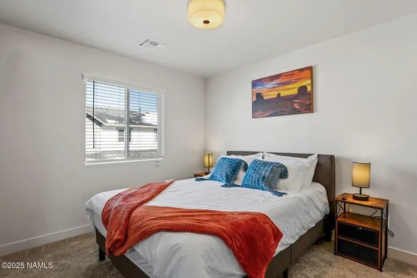 a bedroom with a bed and painting on the wall