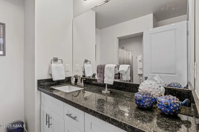 a bathroom with a granite countertop sink and a mirror