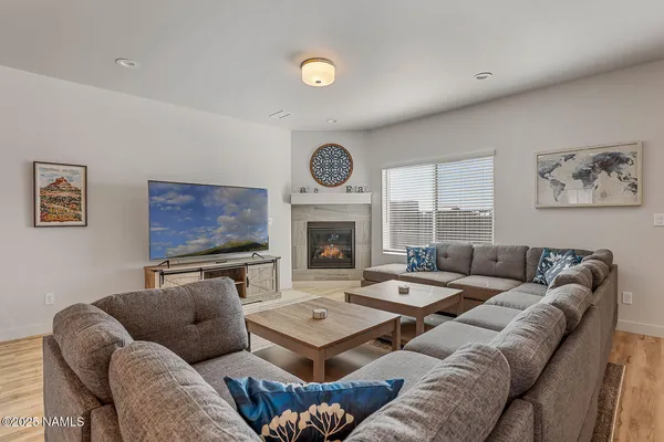 a living room with furniture a fireplace and a large window