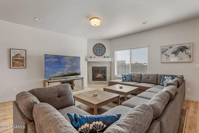 a living room with furniture a fireplace and a large window