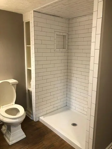 a bathroom with a toilet and a shower