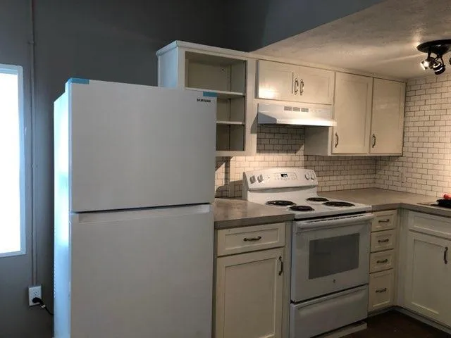 a kitchen with stainless steel appliances a refrigerator sink and cabinets