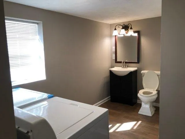 a bathroom with a toilet sink and mirror