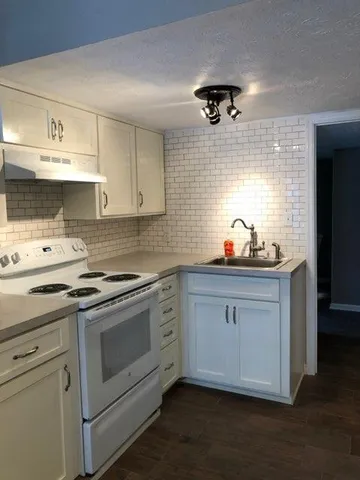 a kitchen with stainless steel appliances a stove a sink and cabinets