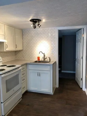 a kitchen with stainless steel appliances a sink stove and cabinets