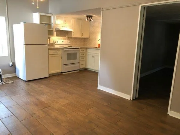 a kitchen with a refrigerator sink stove and cabinets