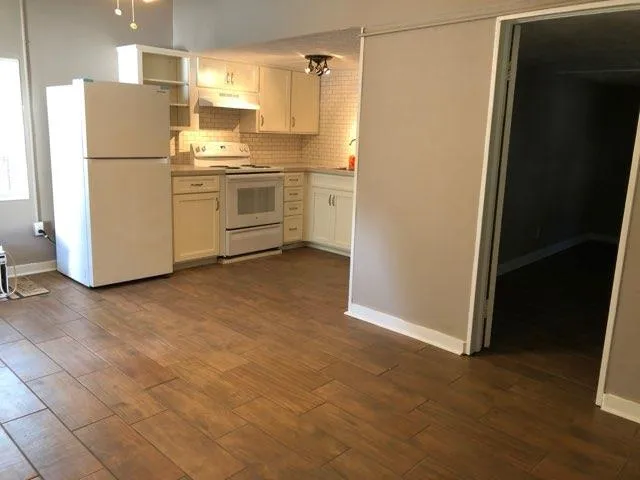 a kitchen with a refrigerator sink stove and cabinets