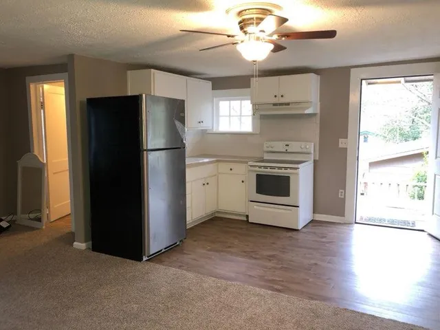 a kitchen with a refrigerator stove and wooden floor
