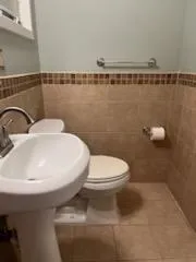 a bathroom with a toilet a sink and mirror