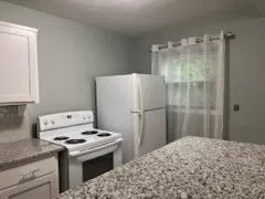 a kitchen with a stove a refrigerator and a stove top oven