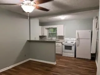a kitchen with a refrigerator and white cabinets