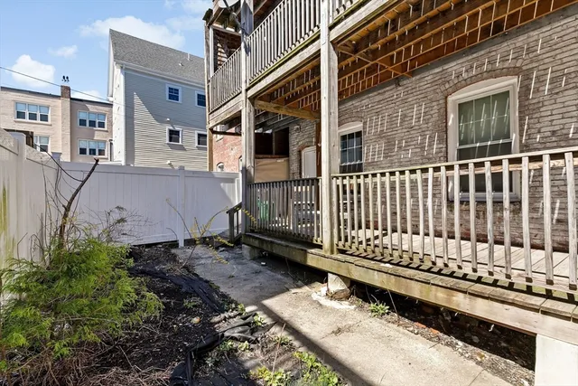 a view of a small house with wooden fence