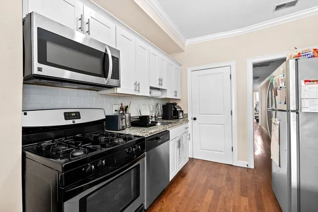 a kitchen with stainless steel appliances a sink dishwasher a stove and a microwave