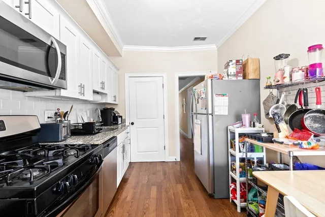 a kitchen with stainless steel appliances a stove a refrigerator and a cabinets