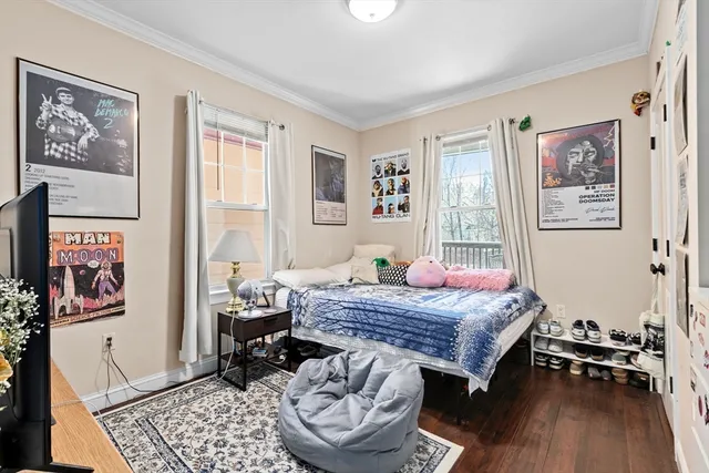 a bedroom with a bed and wooden floor