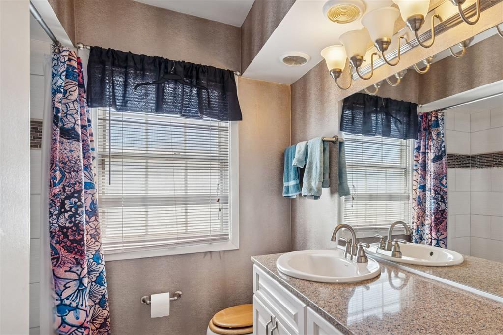 19 Sandpiper Road Tampa, FL 33609 - Photo 43 of 64 a bathroom with a sink a mirror a toilet and shower