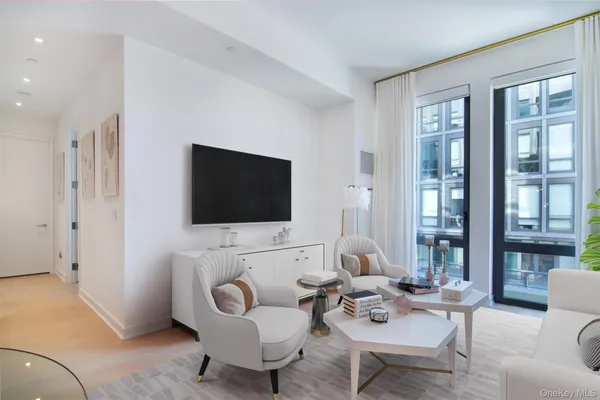 a living room with furniture a flat screen tv and a large window
