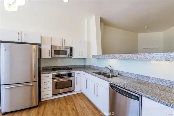 a kitchen with a sink a microwave a stove and refrigerator