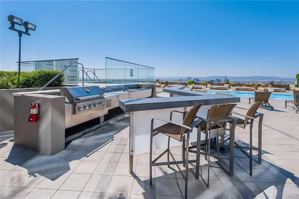 a room with stainless steel appliances kitchen island granite countertop a table and chairs in it