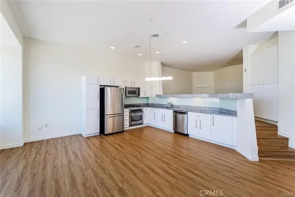 a large kitchen with a center island stainless steel appliances and cabinets
