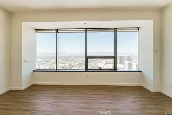 a view of a room with wooden floor and a window