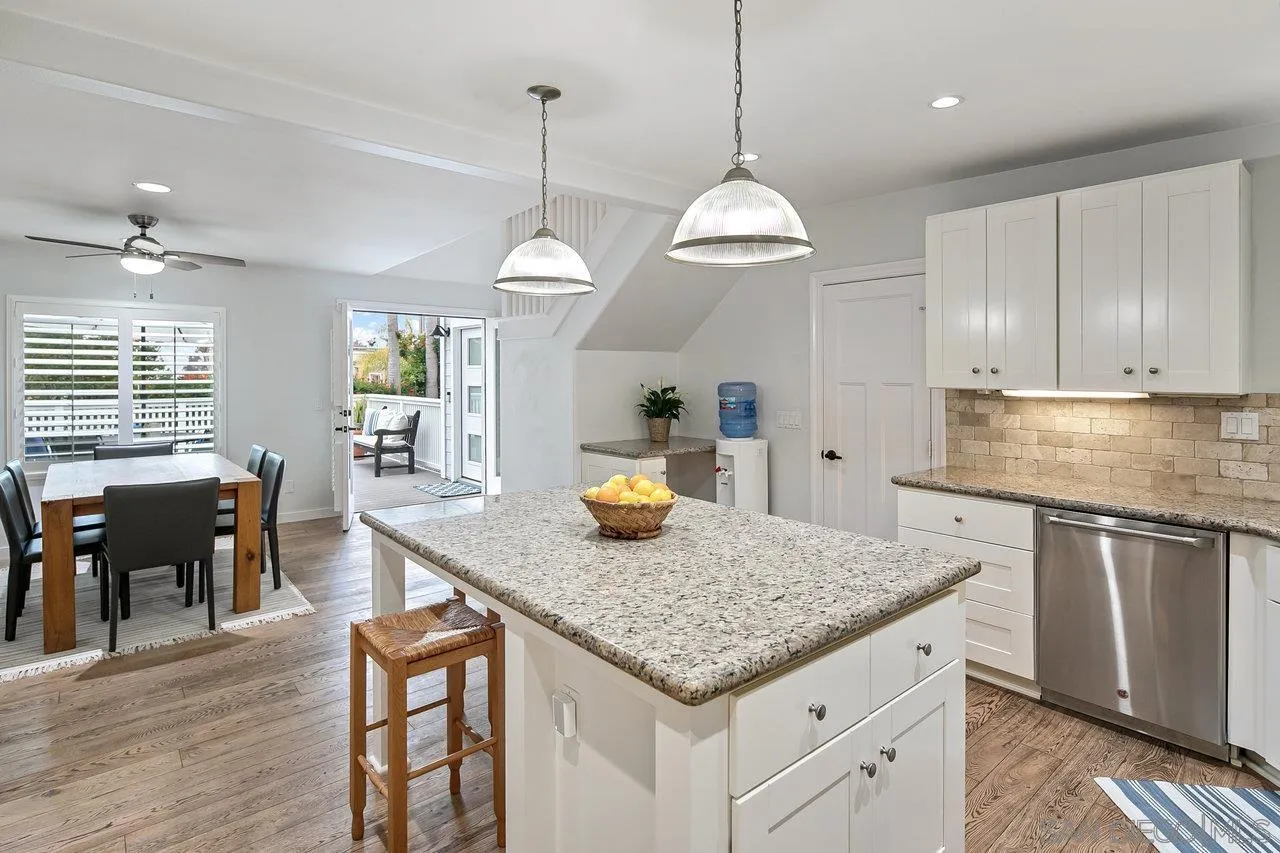 1258 Oak Avenue Carlsbad, CA 92008 - Photo 9 of 29 a kitchen with granite countertop stainless steel appliances a stove center island a dining table and chairs