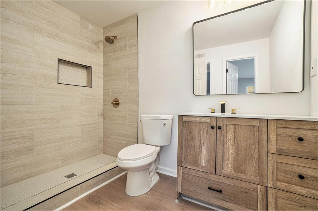 2901 Lenox Road Northeast, Unit 901 Atlanta, GA 30324 - Photo 12 of 18 a bathroom with a toilet a sink a vanity and mirror