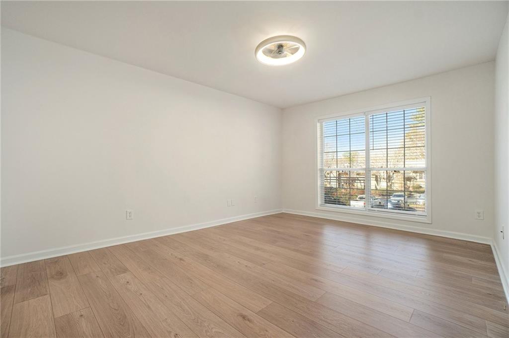 2901 Lenox Road Northeast, Unit 901 Atlanta, GA 30324 - Photo 9 of 18 an empty room with wooden floor and windows