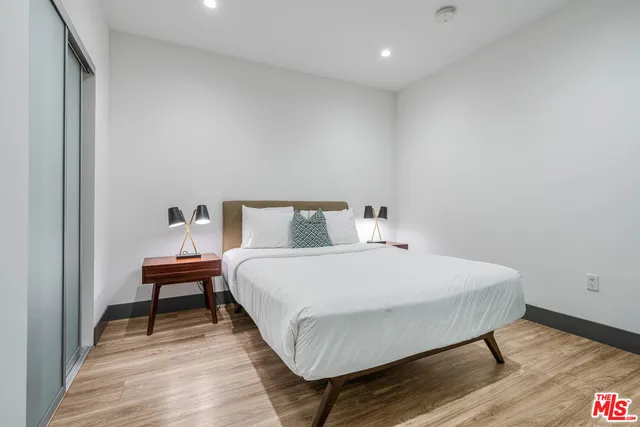 a bedroom with a bed and wooden floor