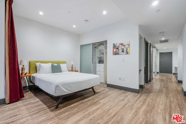 a spacious bedroom with a bed and wooden floor