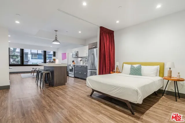 a bedroom with a bed and a view of kitchen