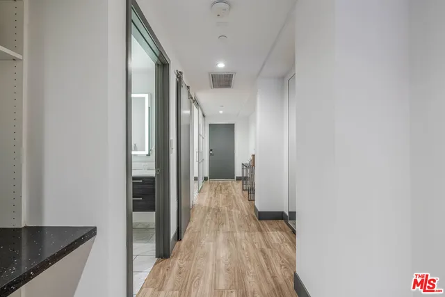 a view of a hallway with wooden floor and staircase
