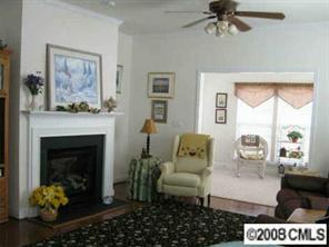 1033 Peridot Court Fort Mill, SC 29708 - Photo 4 of 8 a living room with furniture a chandelier and a fireplace