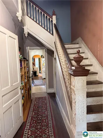 a view of a hallway with wooden floor and staircase