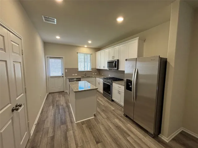 a kitchen with stainless steel appliances granite countertop a refrigerator sink and stove