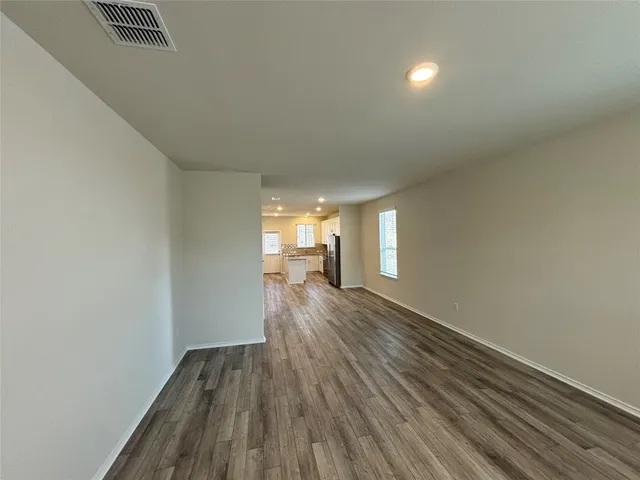 a view of a room with wooden floor and a window