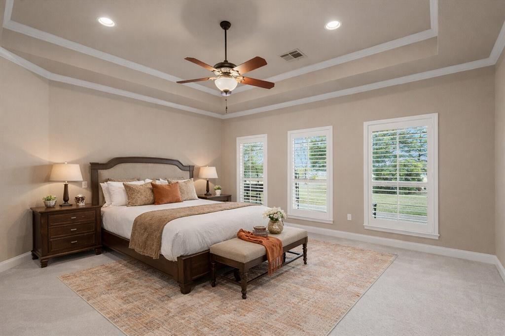 504 Casa Del Rancho Road Lorena, TX 76655 - Photo 22 of 39 a spacious bedroom with a bed a chandelier and a window