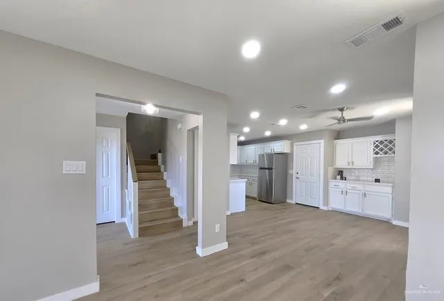 an empty room with wooden floor and windows