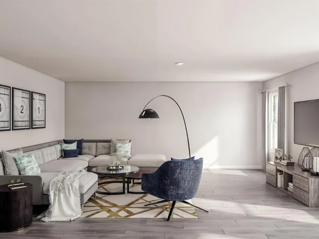 a living room with furniture a flat screen tv and a window