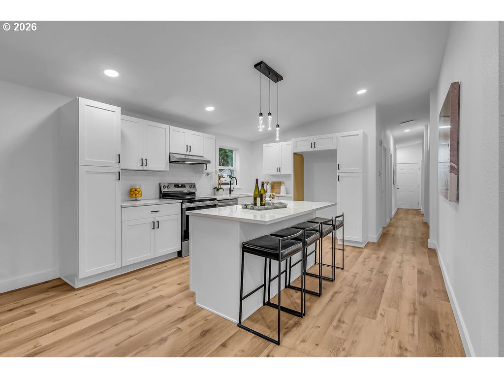 241 Northwest Wade Street Estacada, OR 97023 - Photo 17 of 45 a kitchen with stainless steel appliances kitchen island granite countertop a refrigerator a sink dishwasher and a stove with wooden floor