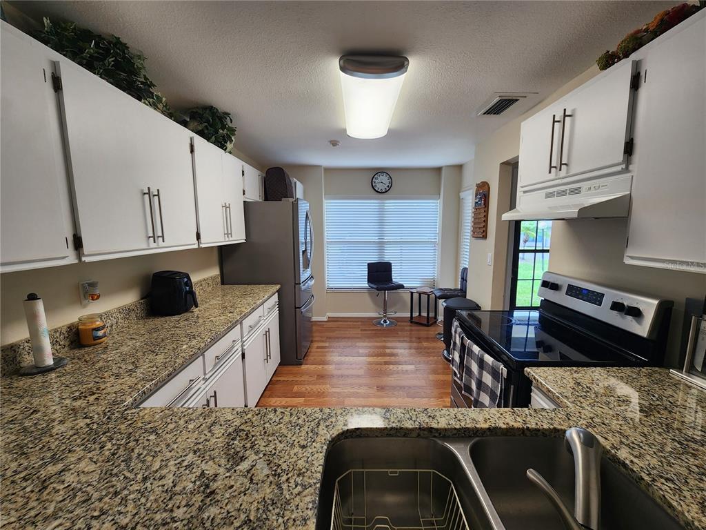 948 North Beneva Road, Unit V25 Sarasota, FL 34232 - Photo 15 of 29 a kitchen with stainless steel appliances granite countertop a sink a stove and a cabinets