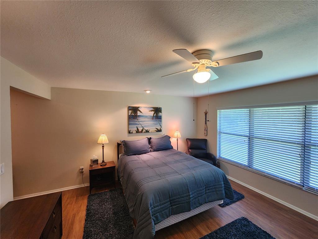 948 North Beneva Road, Unit V25 Sarasota, FL 34232 - Photo 4 of 29 a bedroom with a bed and a ceiling fan with a wooden floor